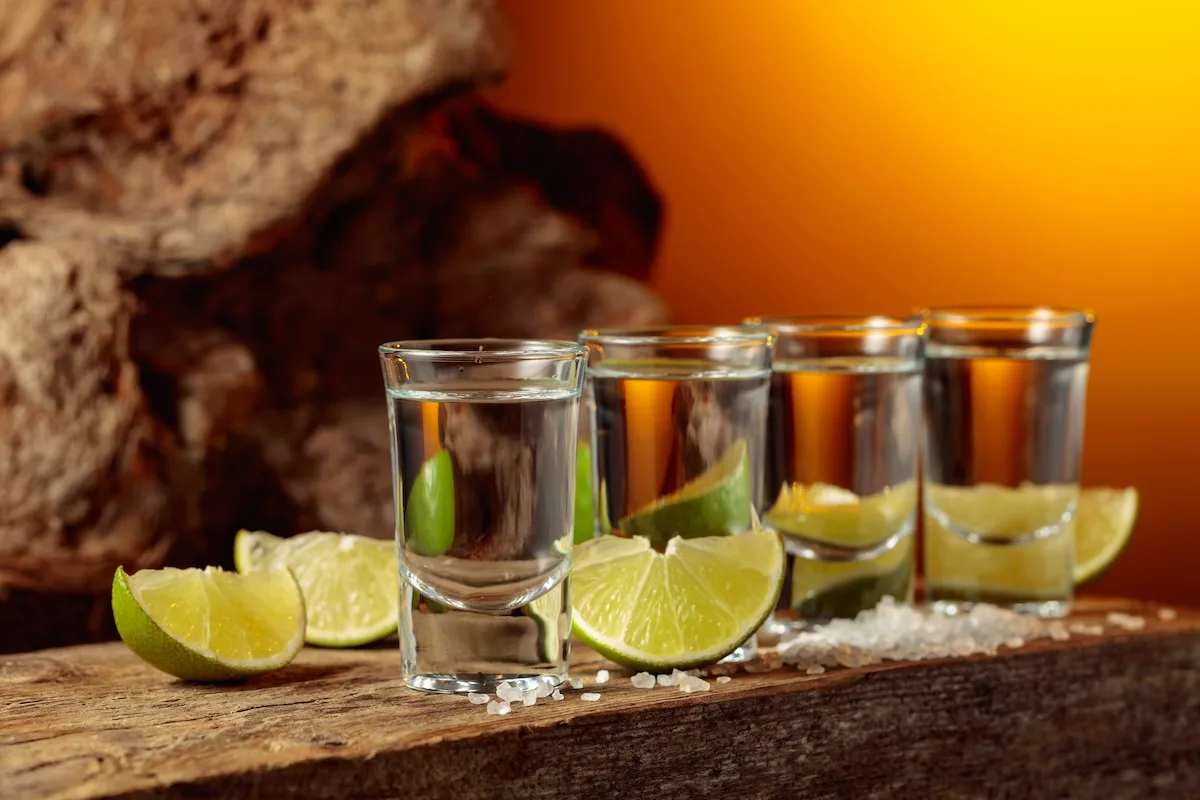 Vier Tequila-Sorten von Blanco bis Añejo mit Limette und Salz auf Holz